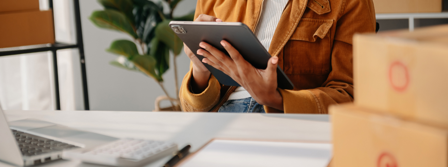 Person mit einem Tablet in der Hand. Es ist nur der Körper zu sehen.